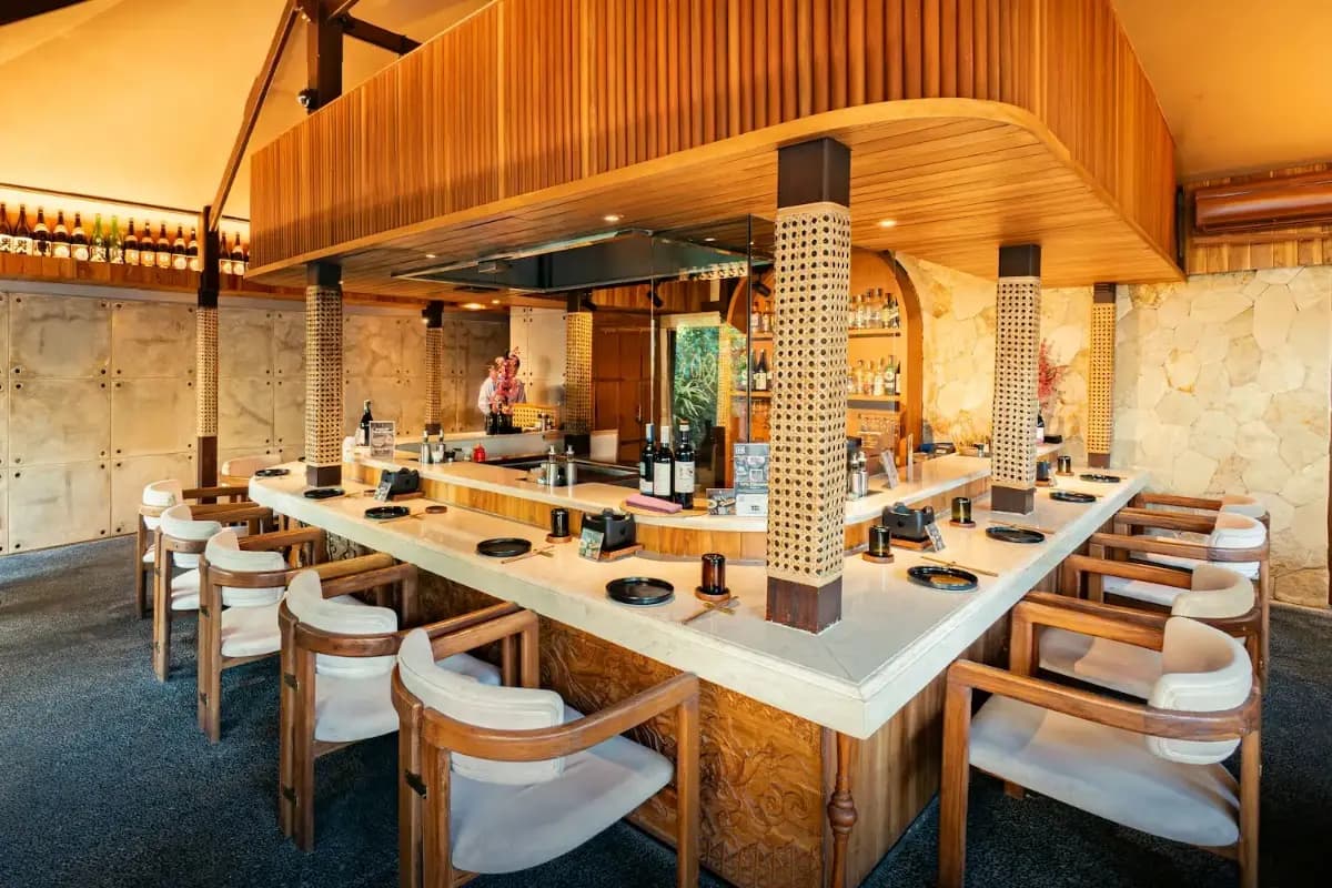 Modern teppanyaki restaurant with counter seating around open grill, showing interactive dining experience in Bali.
