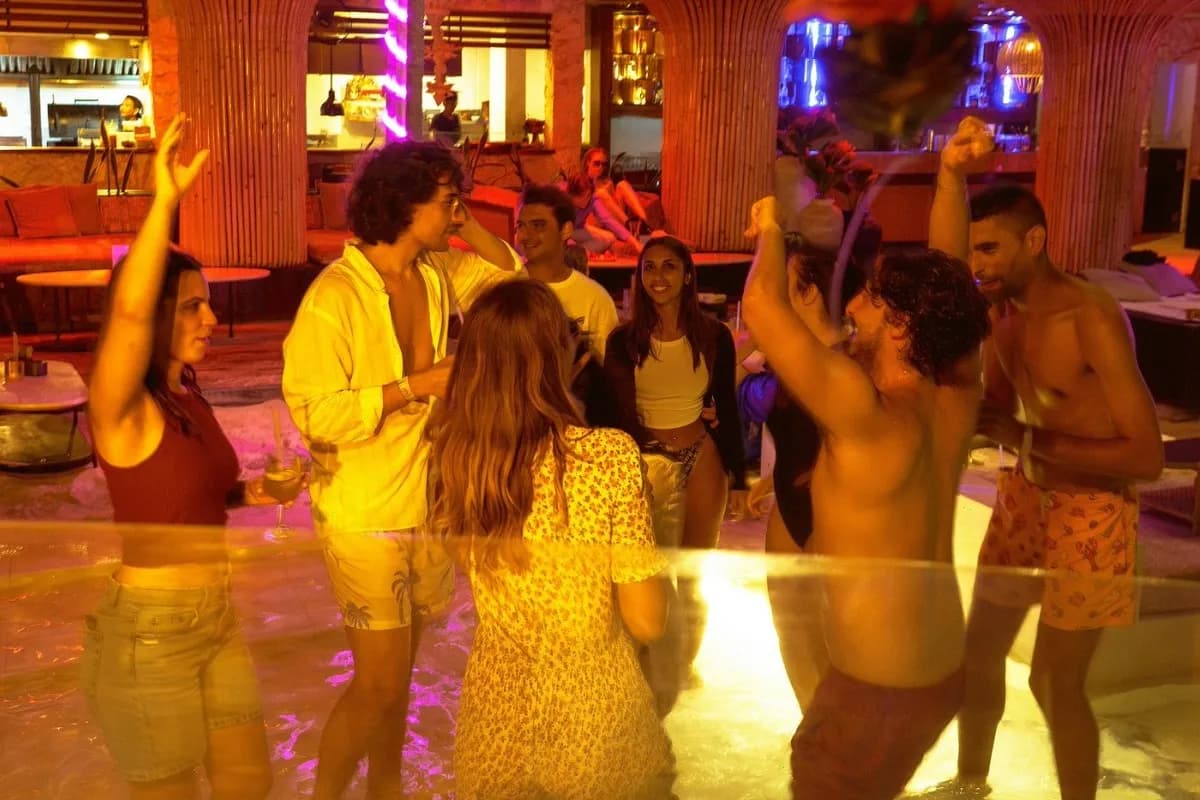 Friends enjoying nightlife in Bali at a lively pool party venue.