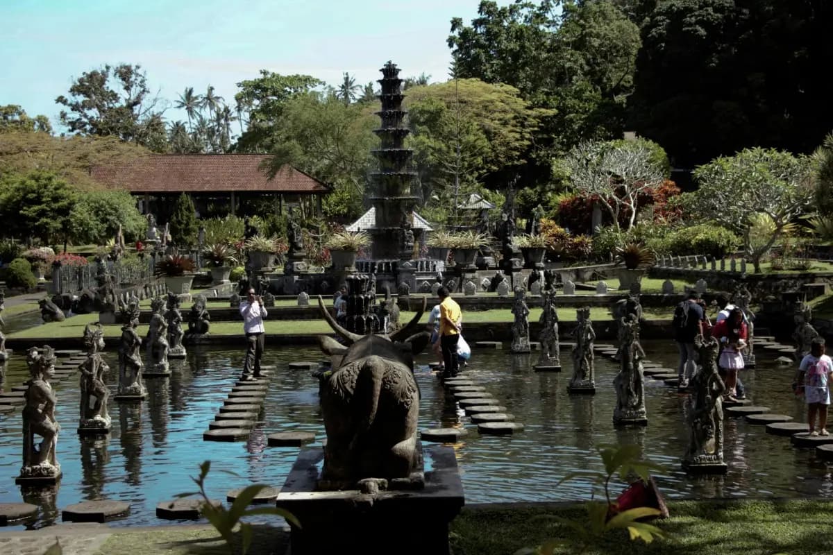 Visitors walk across stone paths and ponds at Tirta Gangga, one of East Bali's most famous attractions.