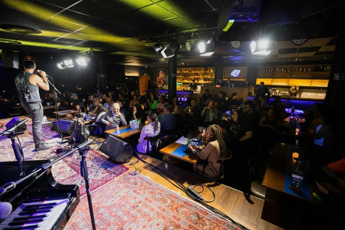 Musician performs on stage while guests watch and dine, showing live music restaurant experience in Bali.